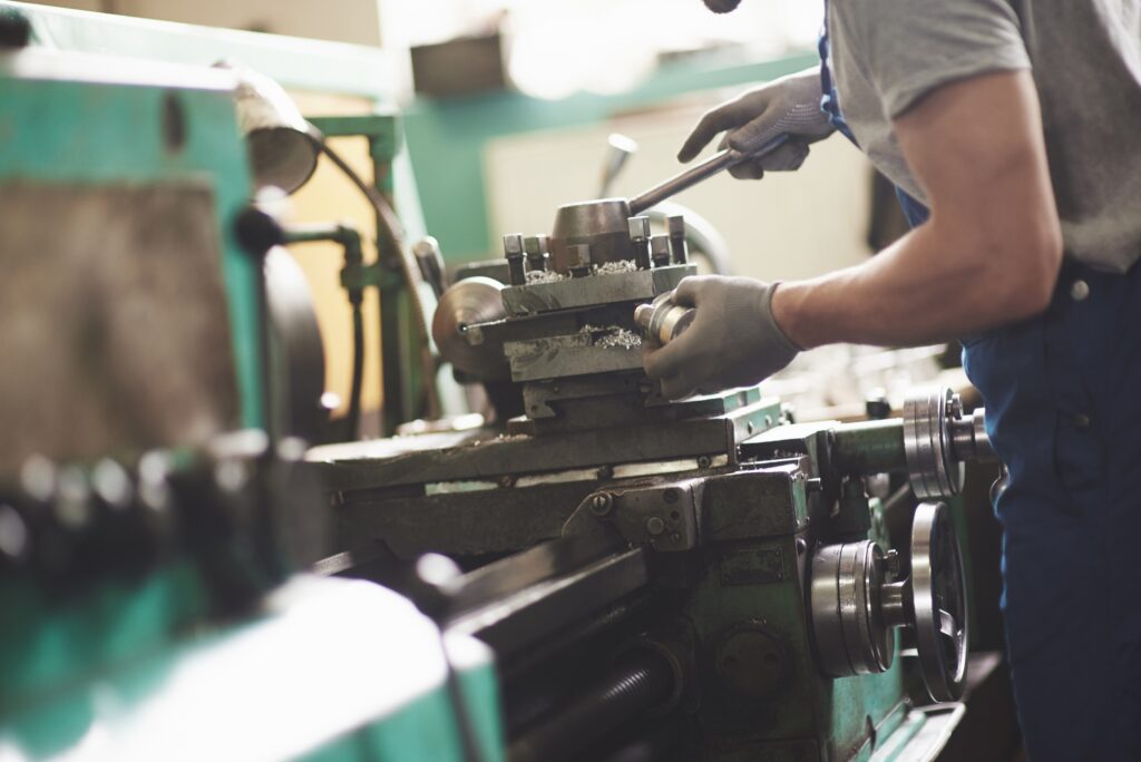 Strong hands hold the steel part. In the old factory